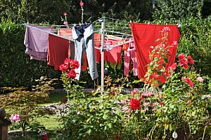 Farbenfroh und luftig - der ideale Einsatzort für eine Wäschespinne ist der Garten Abbildung: Wäschespinne im Garten